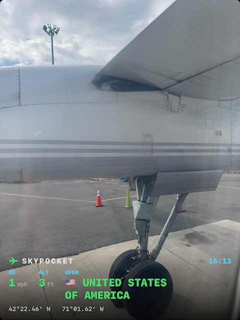 Real photo at the gate in Boston: polished wing and engine outside the window, stamped 1 mph at 3 ft, the recording already running